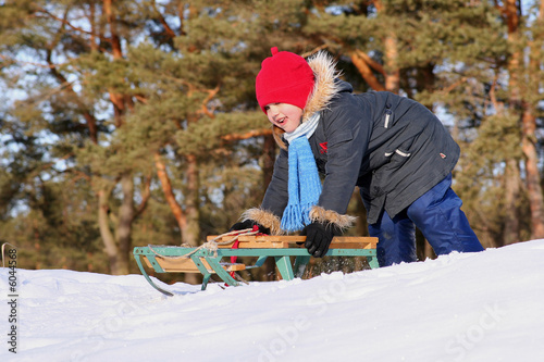 Girl sledding in sunny winter day photo