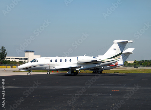 Business jet parked on the airport tarmac © icholakov