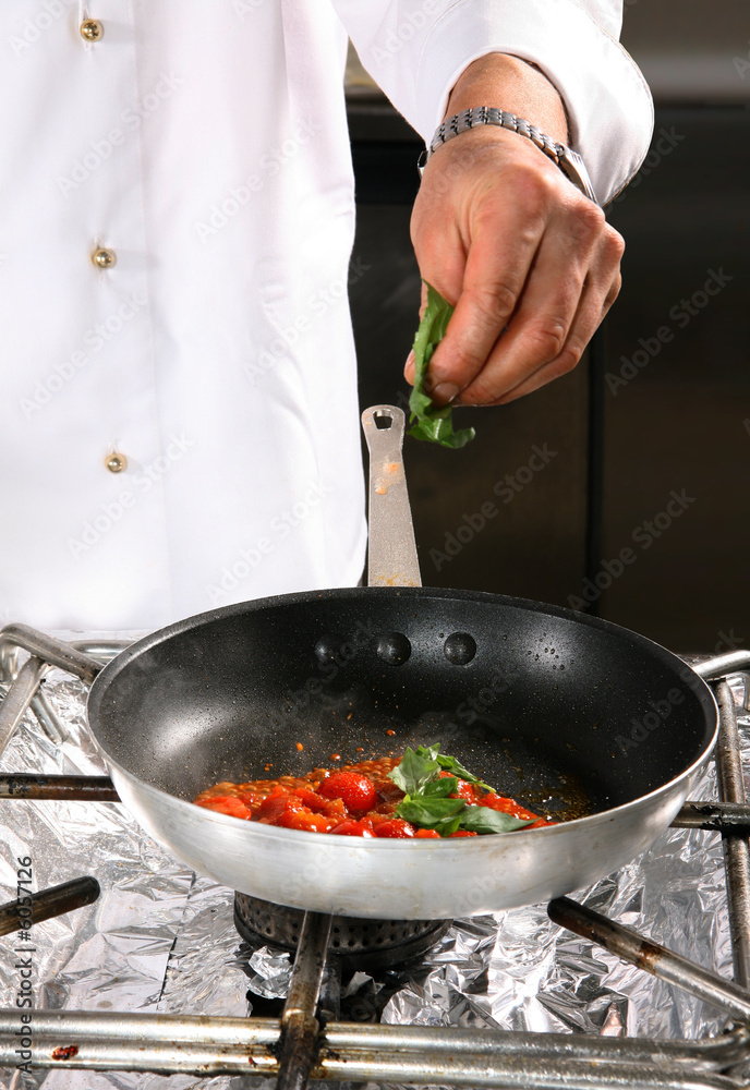 Chef preparing tomato on professional kitchen in restaurant Chef preparing tomato on professional kitchen in restaurant