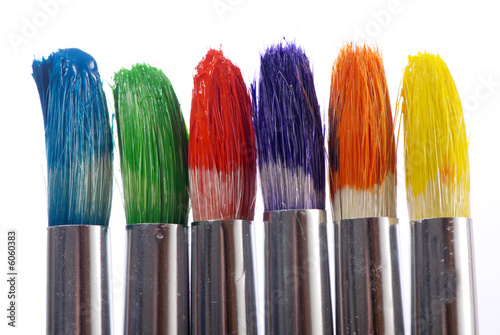 The tips of three colorful paintbrushes ready to be used.