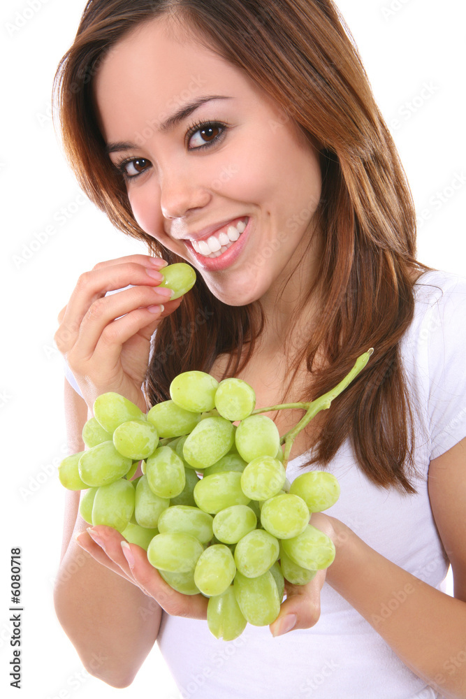 A young, pretty, and healthy woman eating grapes A young, pretty, and healthy woman eating grapes