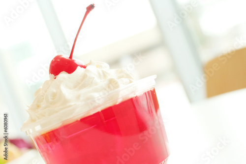Red delicious gelation dessert with whip cream and cherry photo