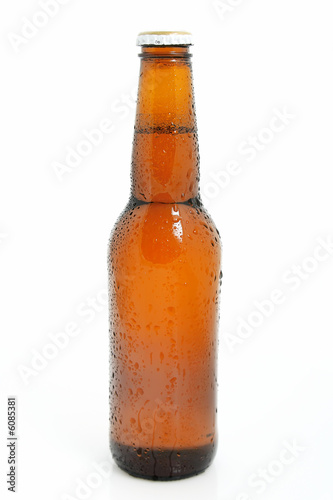 Chilled brown beer bottle over white background