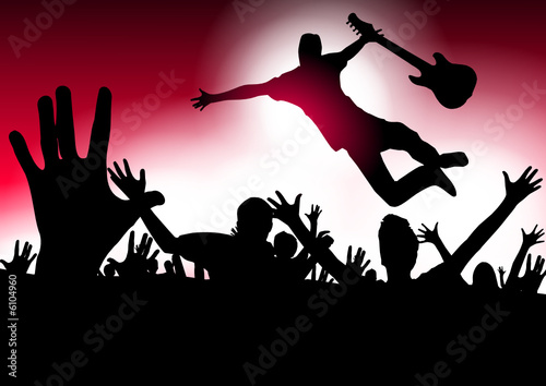 Music star jumping with the guitar in a concert