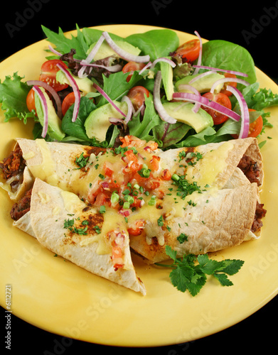 Beef and red kidney bean enchiladas with cheese and salad. photo