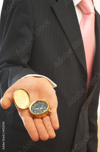 businessman holding an old compass on white