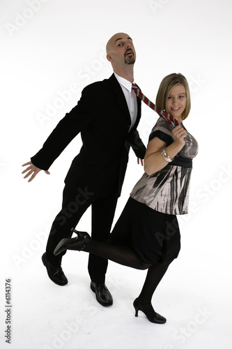 businesswoman is pulling businessman on his tie © Lukas Skarits