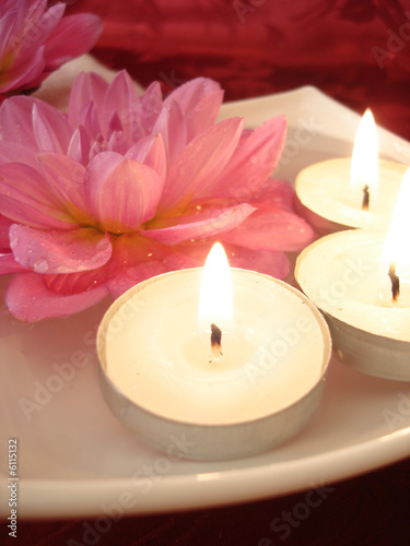 Spa essentials  candles and pink flowers on water 