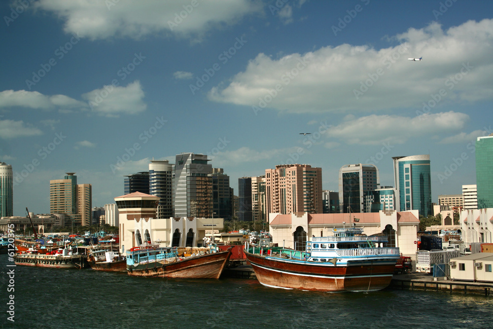 Fototapeta premium Dubai skyline with river, blue sky and white clouds