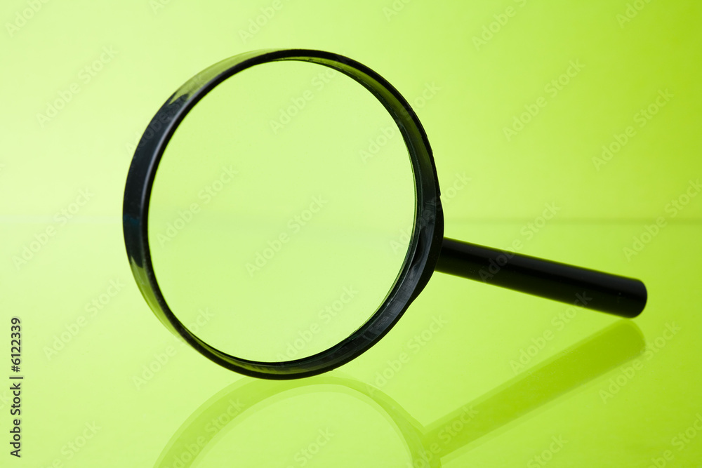 Magnifying glass on green background Magnifying glass on green background