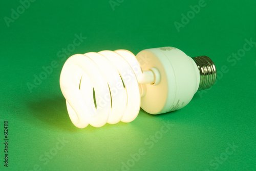 a compact fluorescent lightbulb on a green background