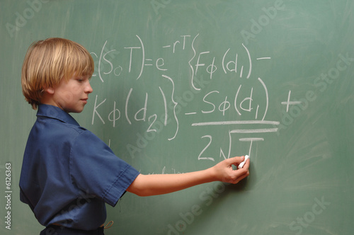 Nine year old boy doing advanced math on a chalkboard