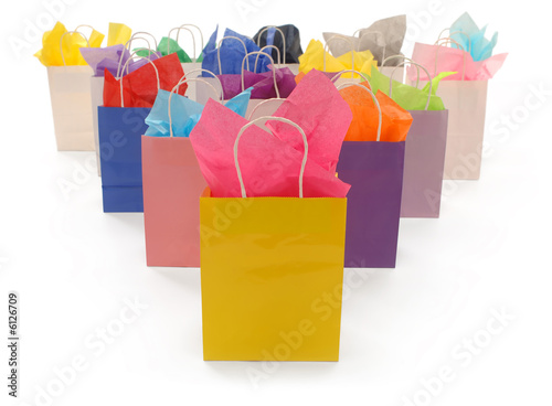 Colorful shopping bags with tissue paper on a white background