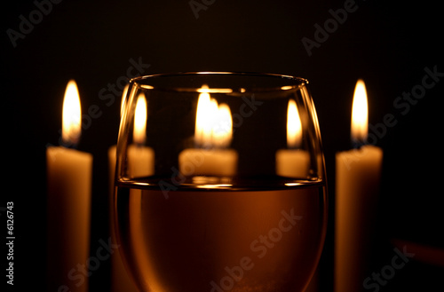 Wine glass with white candlelights in the background.