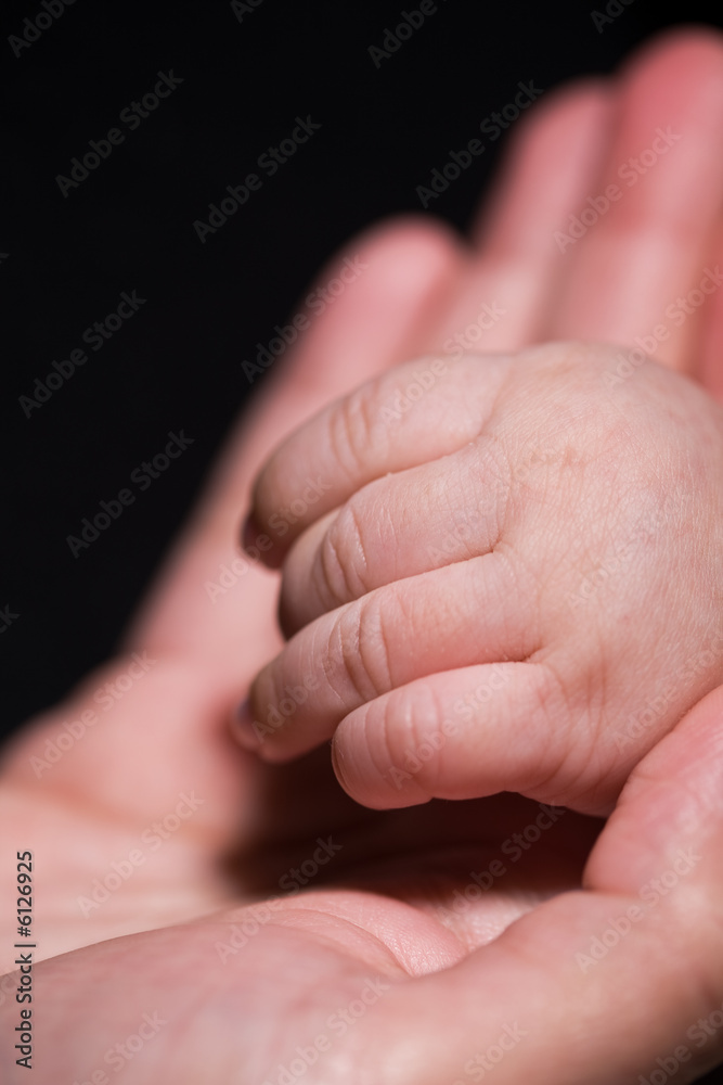 A shot of a mother holding her baby's hand