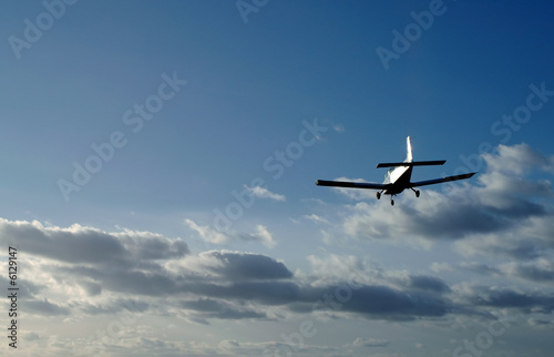 light aircraft on landing approach at sunset