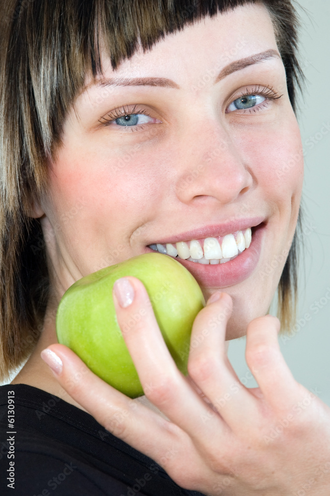 The young beautiful girl holds a green apple in a hand The young beautiful girl holds a green apple in a hand