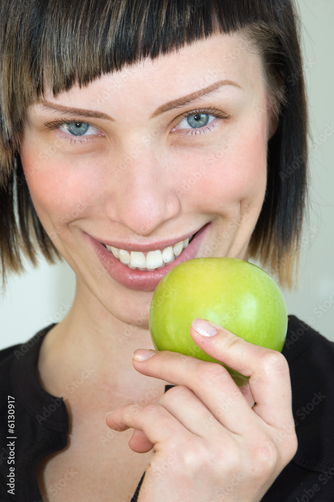 The young beautiful girl holds a green apple in a hand The young beautiful girl holds a green apple in a hand