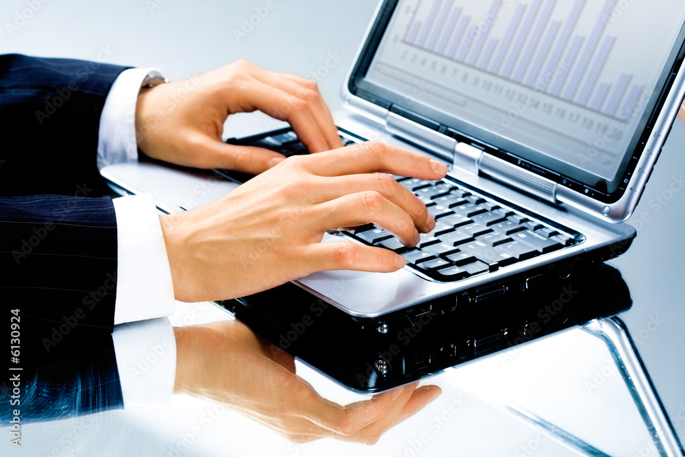 Image of human hand typing a business document on the laptop Image of human hand typing a business document on the laptop