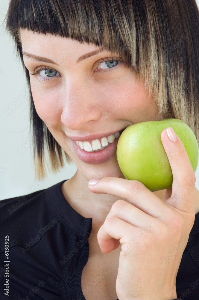 The young beautiful girl holds a green apple in a hand The young beautiful girl holds a green apple in a hand