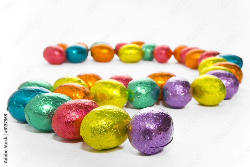 A snaking line of colourful chocolate Easter eggs A snaking line of colourful chocolate Easter eggs
