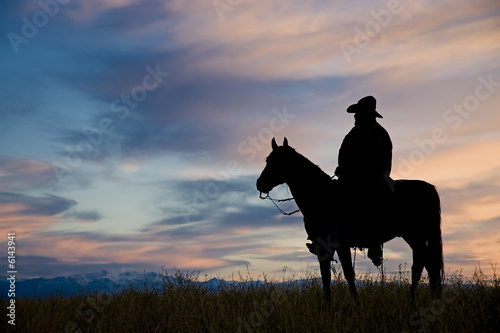Cowboy on horseback,silhouetted against a dawn sky  © outdoorsman