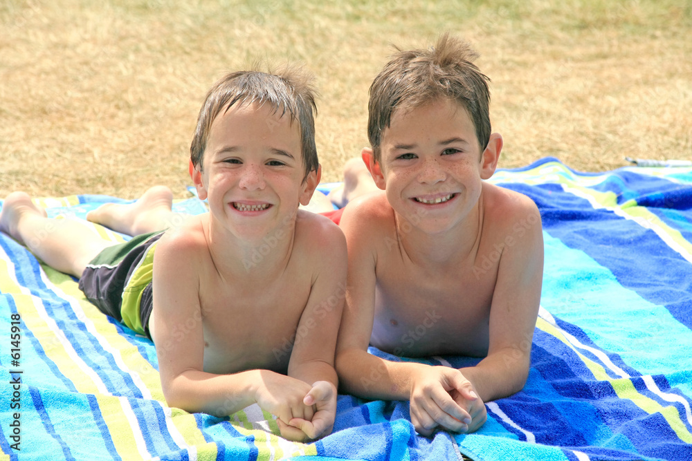 Fototapeta premium Boys Laying on Beach Towels