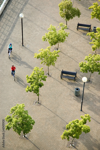 overhead view of a couple cycling through a plaza