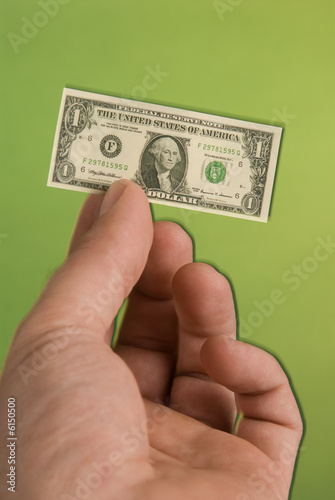 a hand holding a miniature United States one dollar bill 