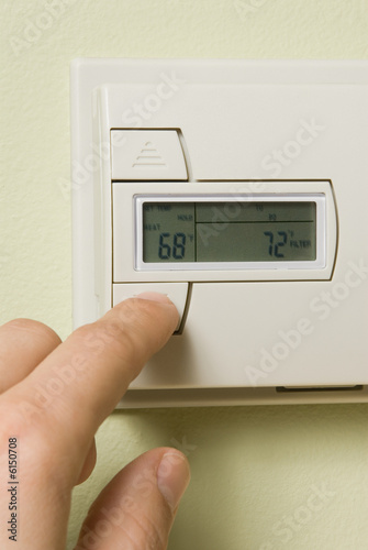 turning down a home thermostat to save energy