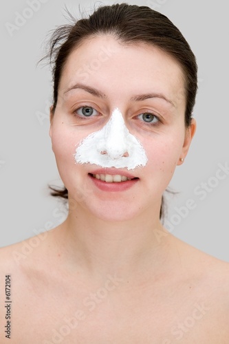 Smiling beautiful woman with a beauty mask on her nose