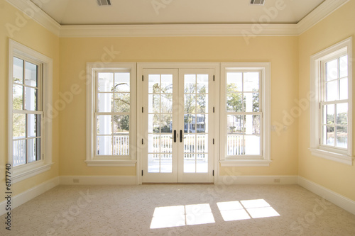 bedroom with windows and doors looking onto porch with view