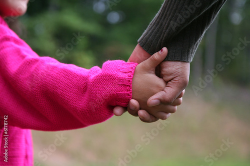A mixed race mother and daughter holding hands
