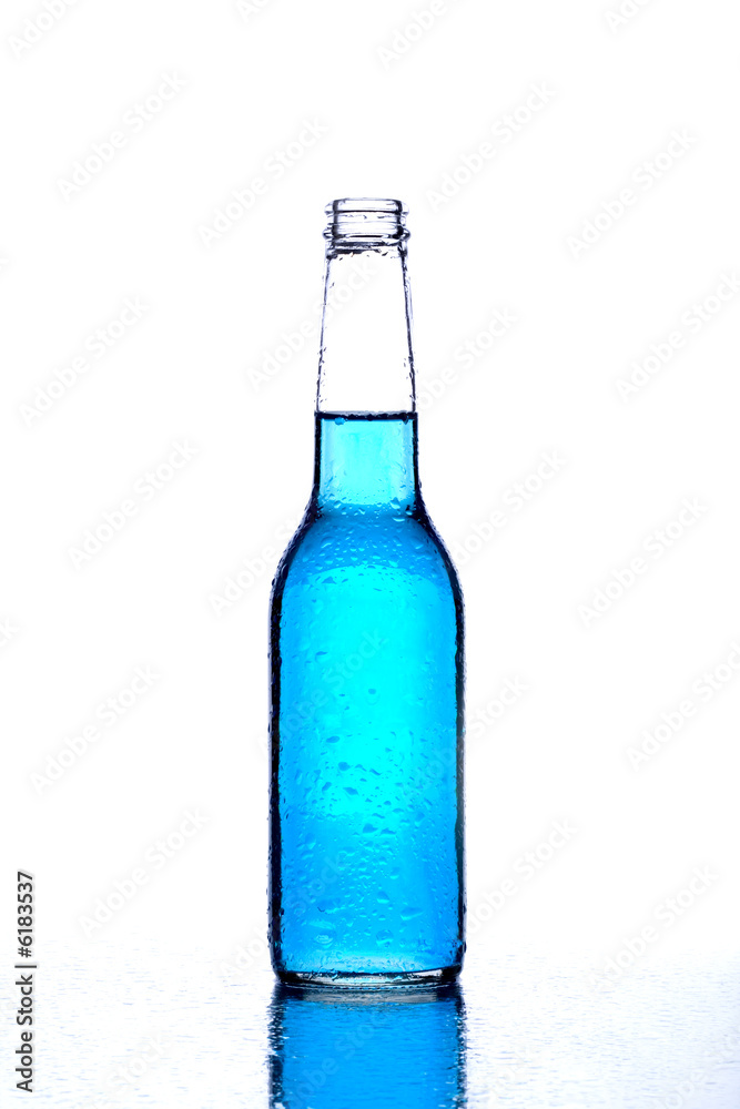 bottle with blue liquid on wet reflective surface on white bottle with blue liquid on wet reflective surface on white