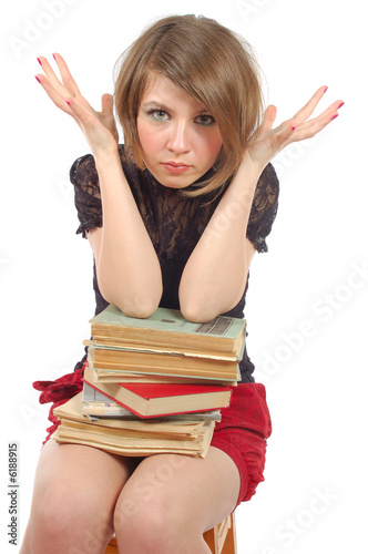 the girl sit in panic with heap of books