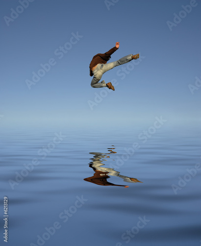 young man jumps high with water reflection