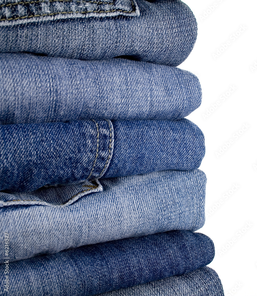 stask of blue jeans over white stask of blue jeans over white