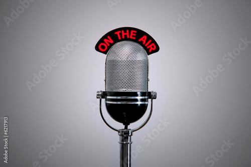 Old retro microphone with illuminated 'On the Air' sign.