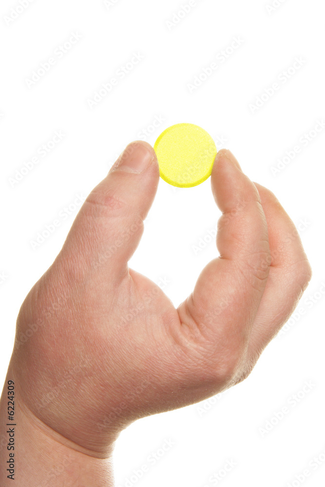 Human hand holding big yellow pill Human hand holding big yellow pill