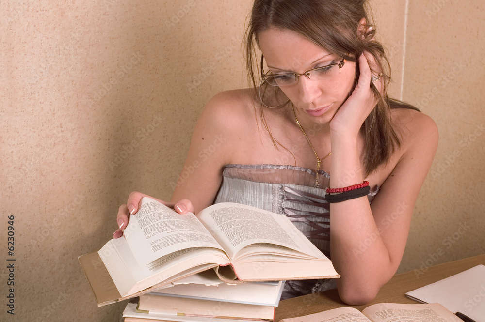 Young beautiful student reading her books in room