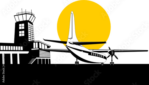 Propeller airplane with control tower in background