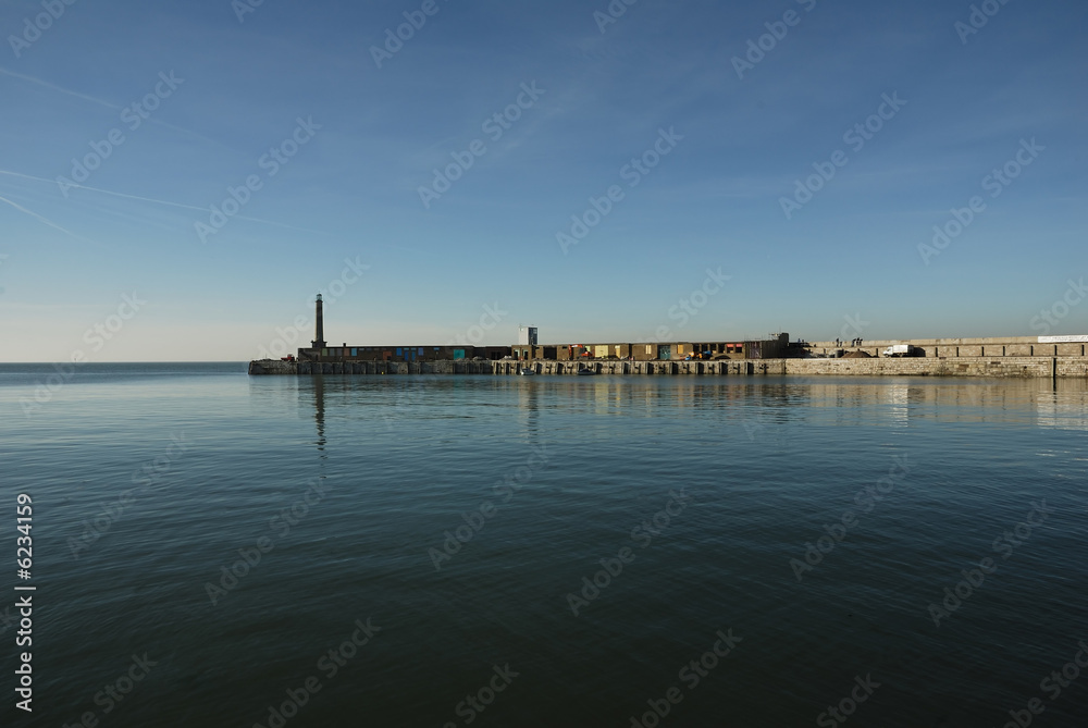 View across a calm sea of Margate harbor in Kent, UK.