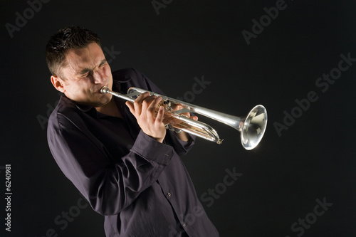 Man in shirt trumpet with might and main. Front view.