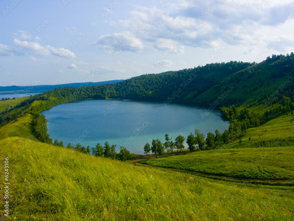 the image of the lake located in a hollow of a hill