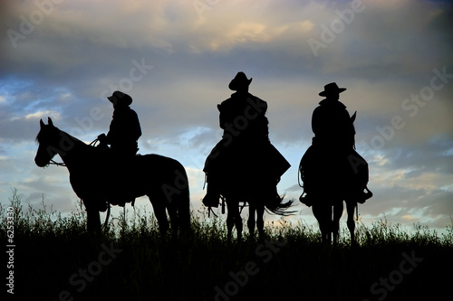 Cowboys on horseback on a Montana ridge at dawn © outdoorsman