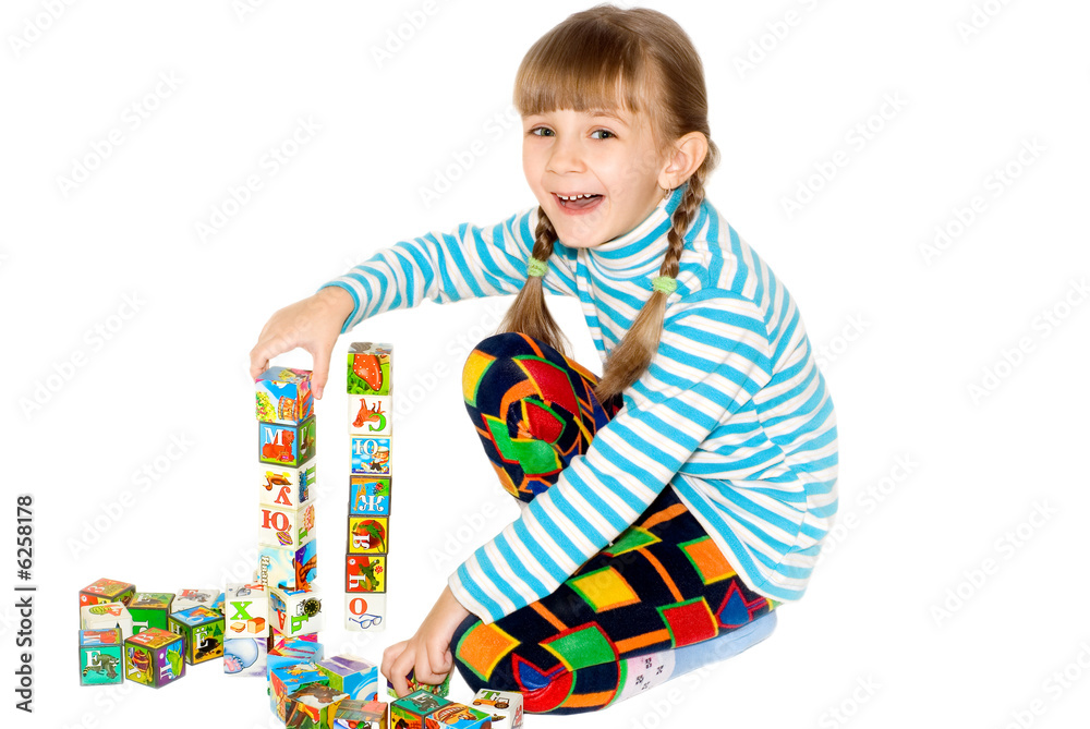 The little girl smiles and plays with bricks . The little girl smiles and plays with bricks .
