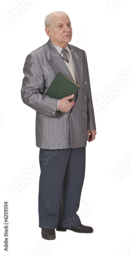 Senior man standing up an holding a book.