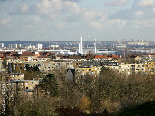 Vue de la ville du Bourget avec fusées blanches au loin.