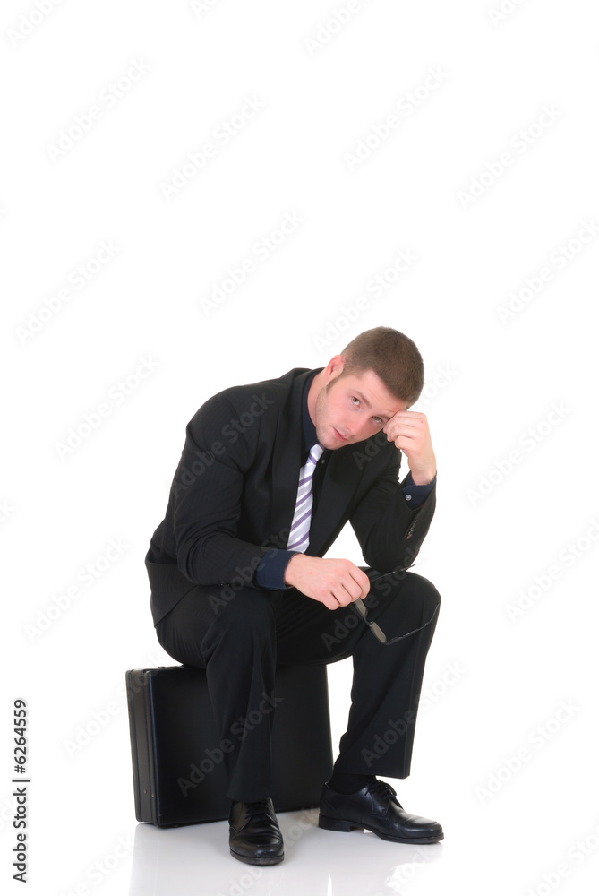 Handsome young businessman, sitting on briefcase, Handsome young businessman, sitting on briefcase,