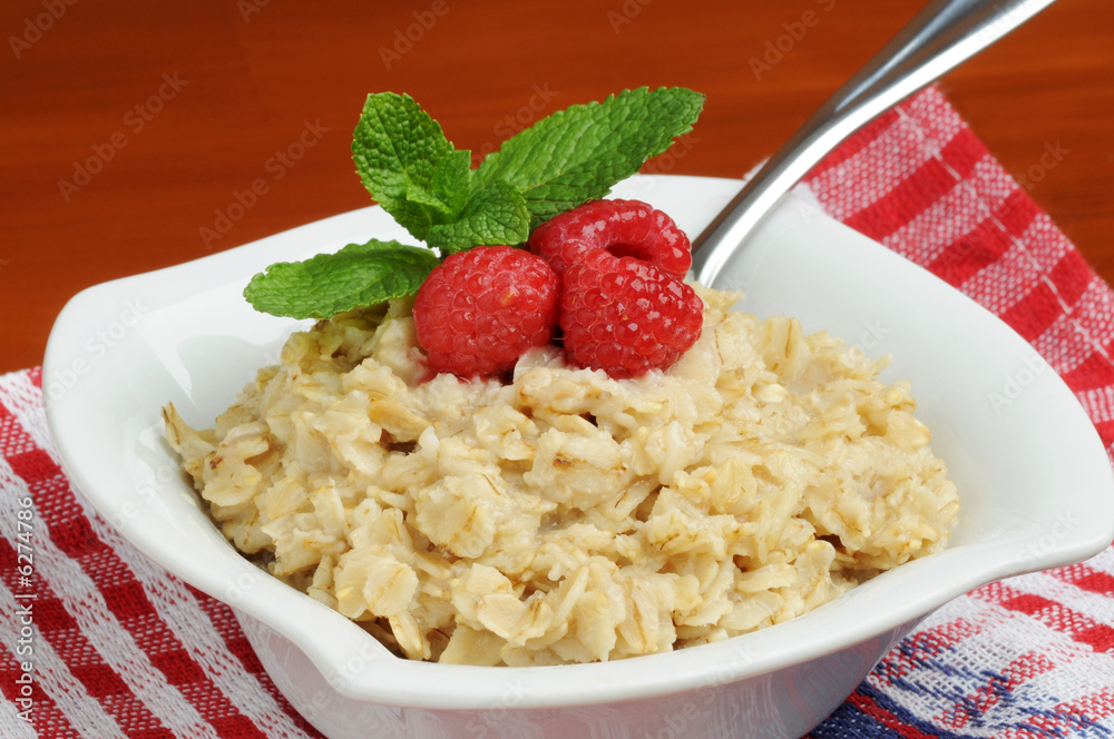 Bowl of healthy oatmeal with fresh raspberries.